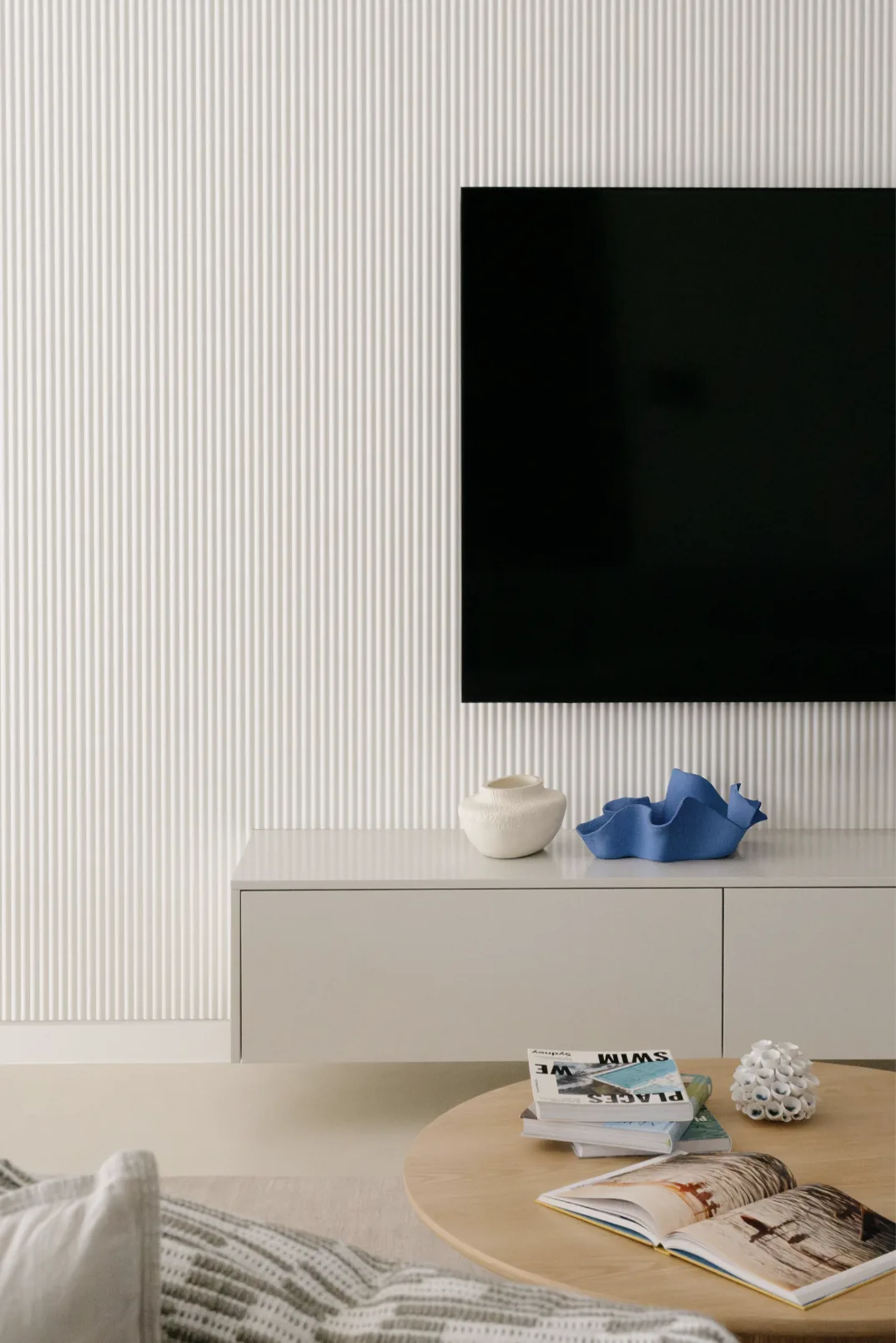Freshwater &mdash; fluted wall with wall-mounted TV, console and round timber coffee table