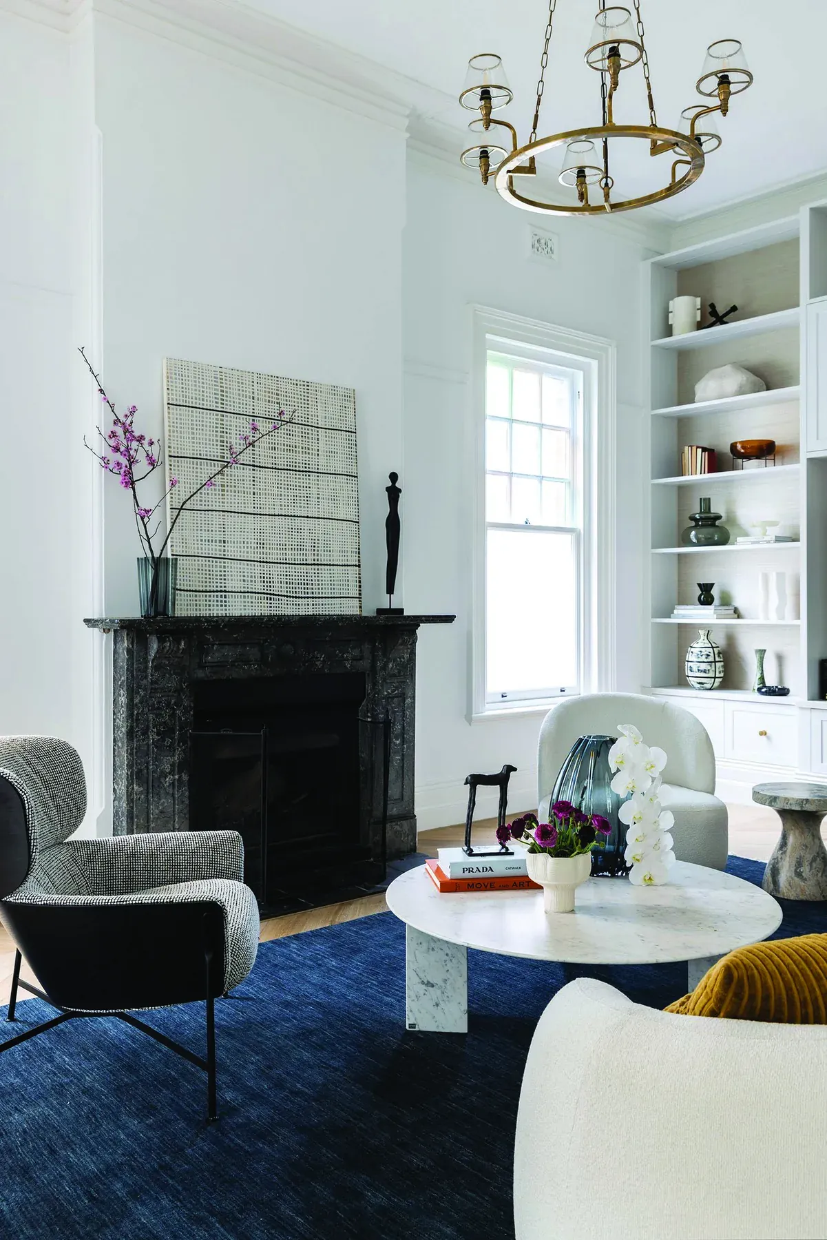 Mosman 01 &mdash; living room with dark marble fireplace, brass chandelier and navy rug