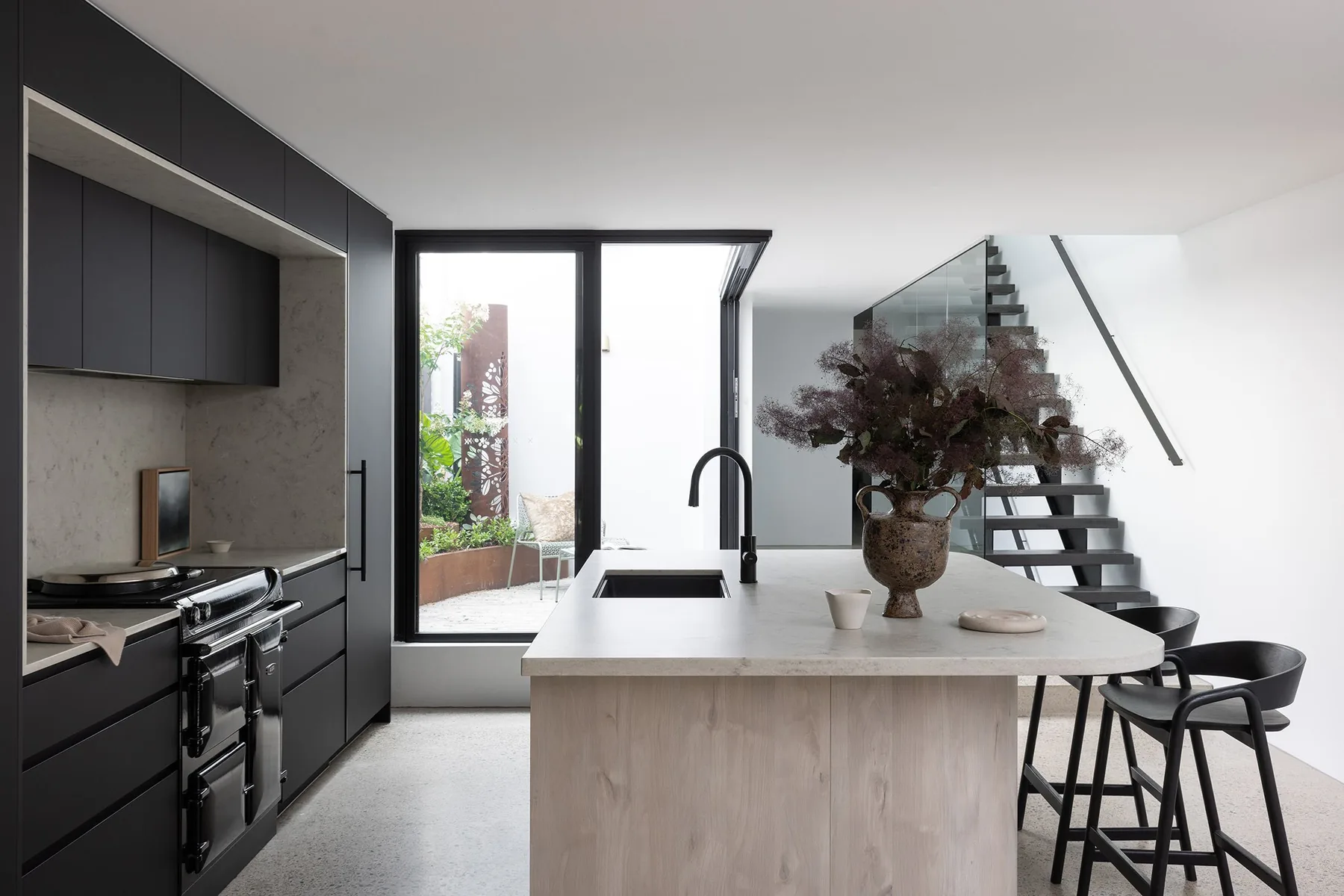 North Sydney &mdash; black kitchen with timber island, stools and glass staircase