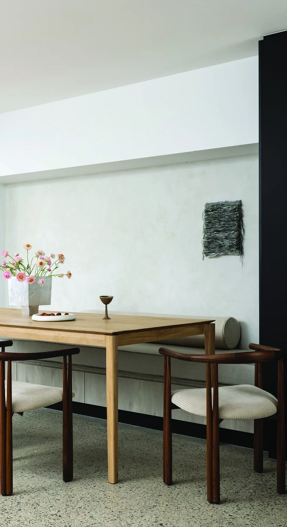 North Sydney &mdash; timber dining table with leather chairs against a pale plaster wall