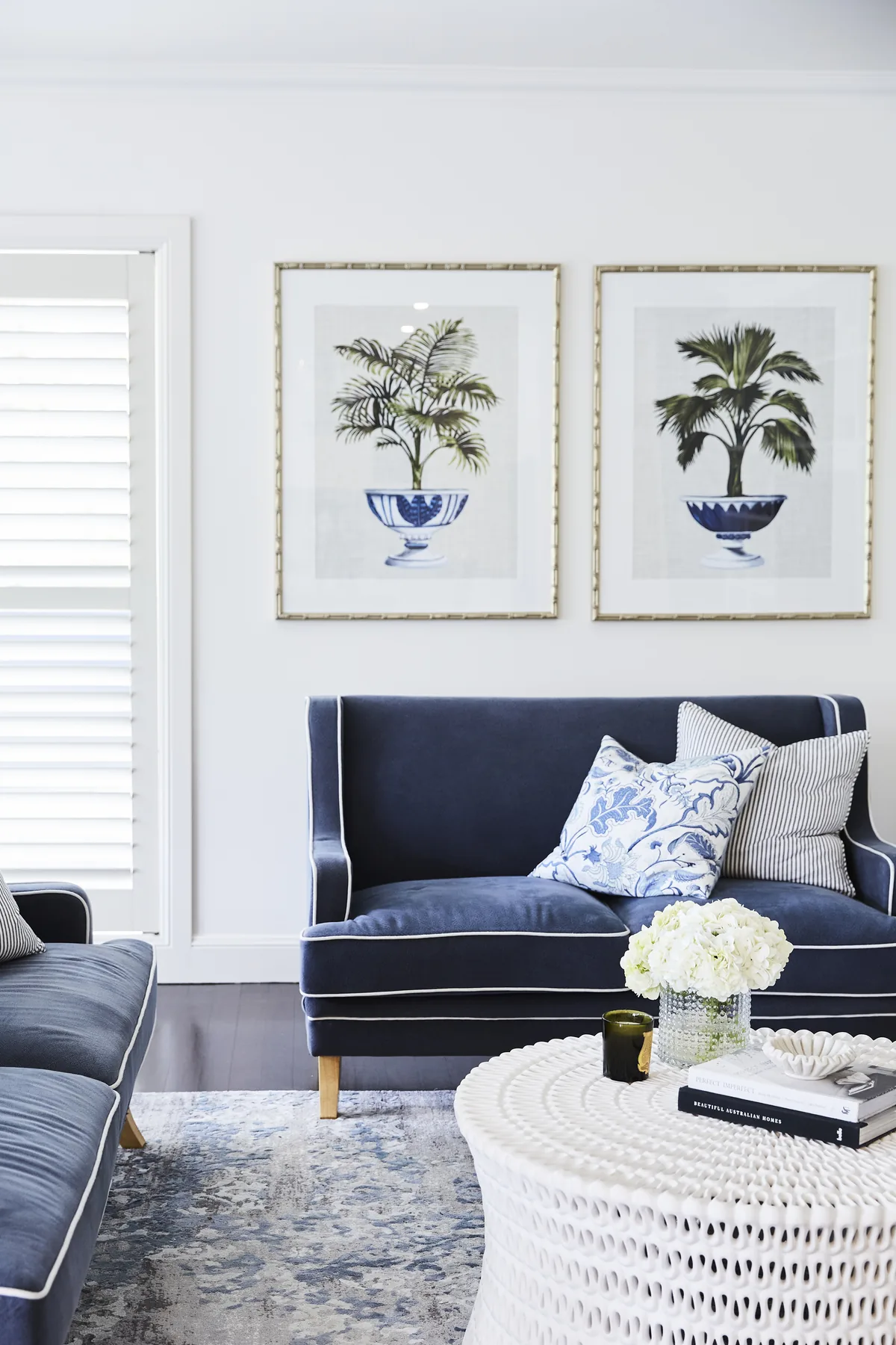 Wahroonga &mdash; navy velvet sofa under framed palm prints with blue and white cushions